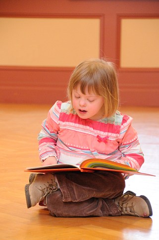 Child with Down syndrome reading