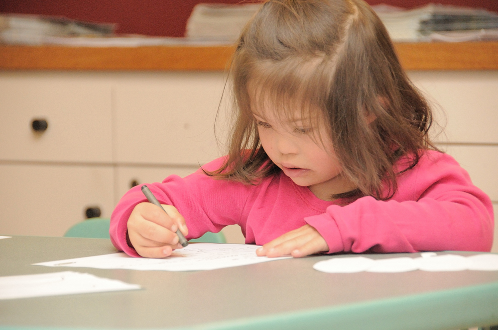 Child with Down syndrome writing