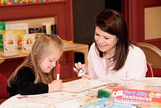Teacher and student with Down syndrome- reading lesson