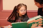 child with Down syndrome reading