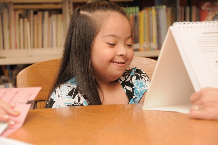 Child with Down syndrome reading
