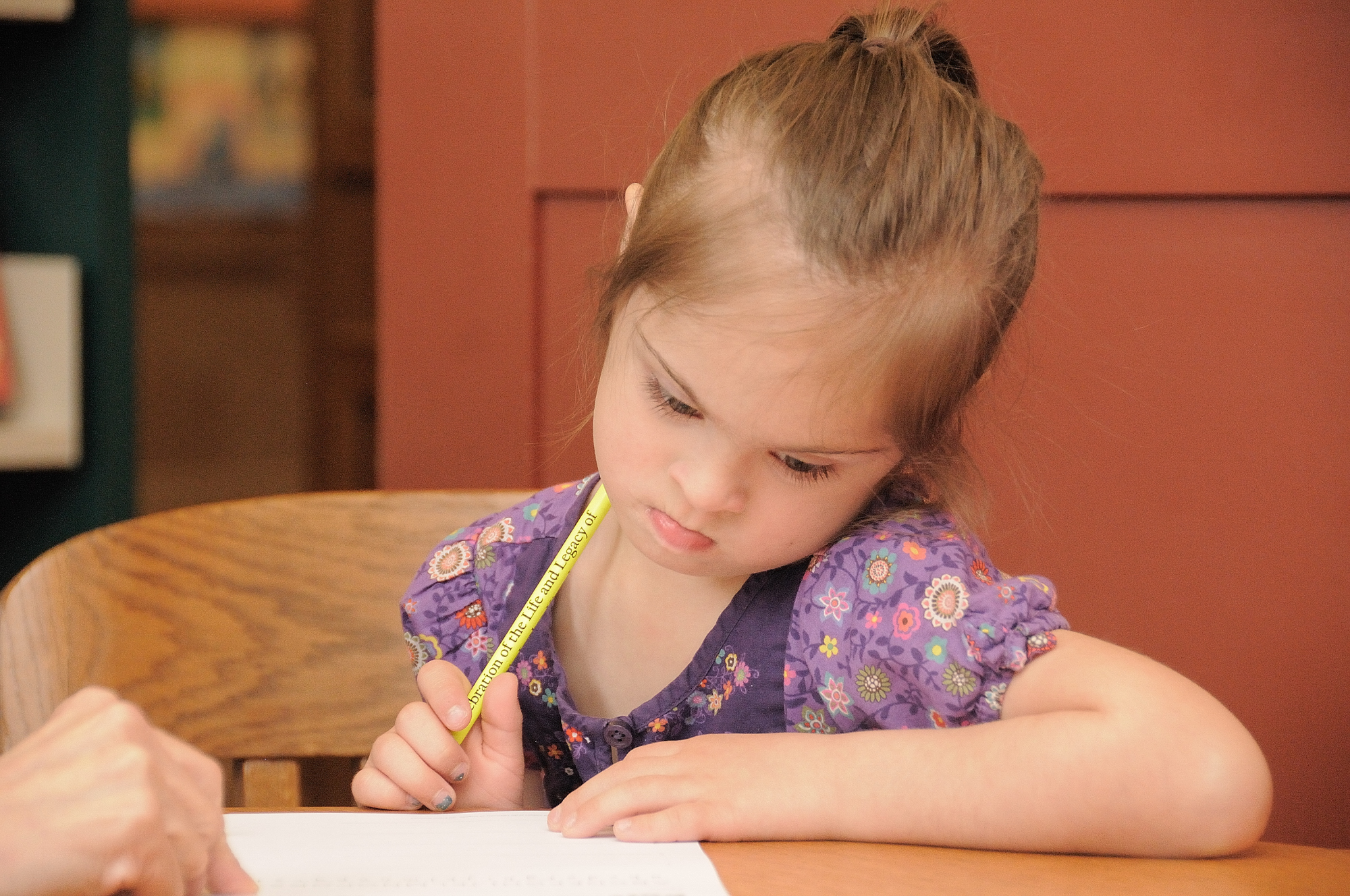 child with Down syndrome writing